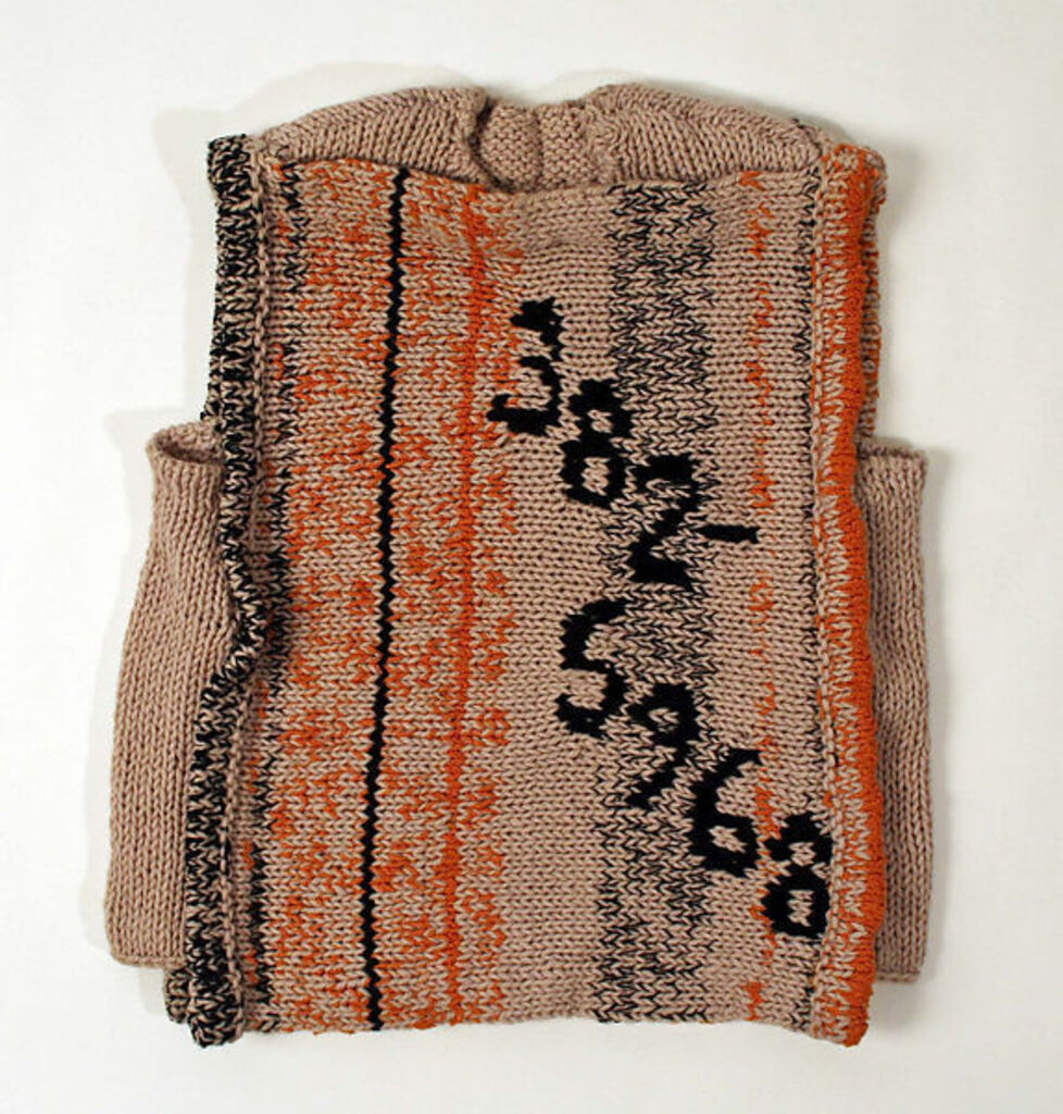 Beige, orange and black knitted sweater with the numbers 382-5968 stitched on