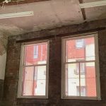 Photograph of windows opening out onto red walls.