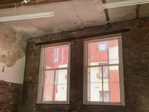 Photograph of windows opening out onto red walls.