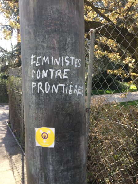 Graffiti on post which reads 'Feministes contre frontieres'.