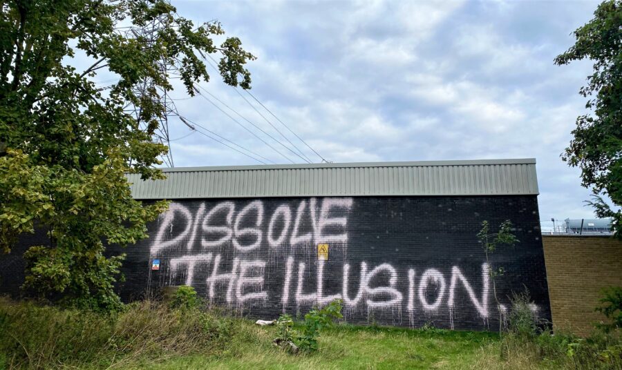 Graffiti which reads, 'Dissolve the illusion...'