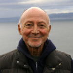 Sylvere Lotringer smiling with a sea behind him