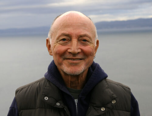 Sylvere Lotringer smiling with a sea behind him